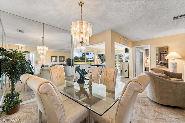 dining space featuring ceiling fan with notable chandelier and a textured ceiling