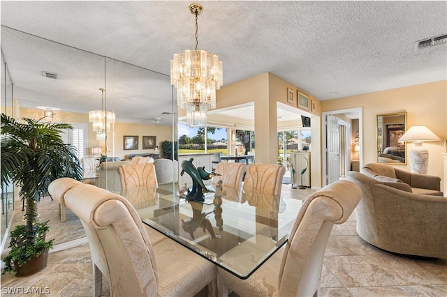 dining space with a chandelier, visible vents, and a textured ceiling