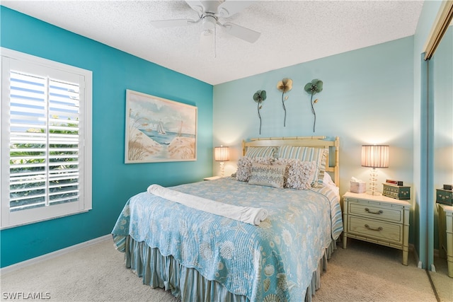 carpeted bedroom with ceiling fan, a closet, and a textured ceiling