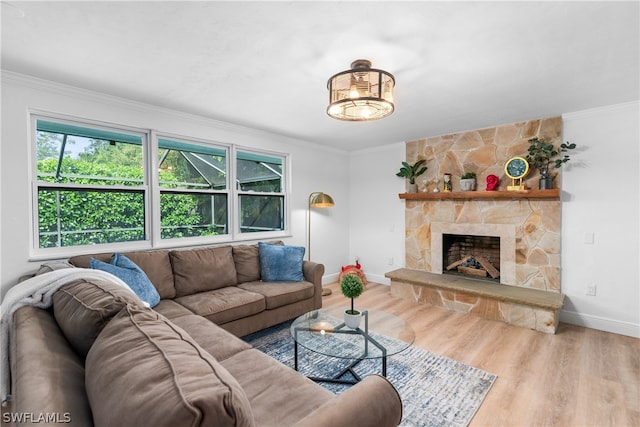 living area featuring a fireplace, baseboards, crown molding, and wood finished floors