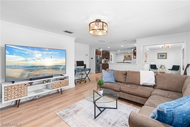 living room featuring light wood-type flooring, visible vents, crown molding, and baseboards