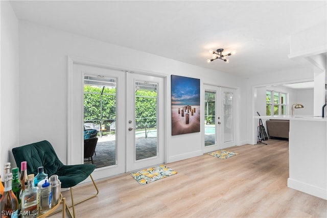 entryway with french doors, baseboards, and light wood finished floors