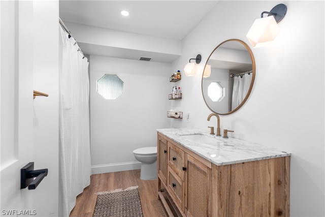 full bathroom featuring toilet, wood finished floors, visible vents, vanity, and baseboards