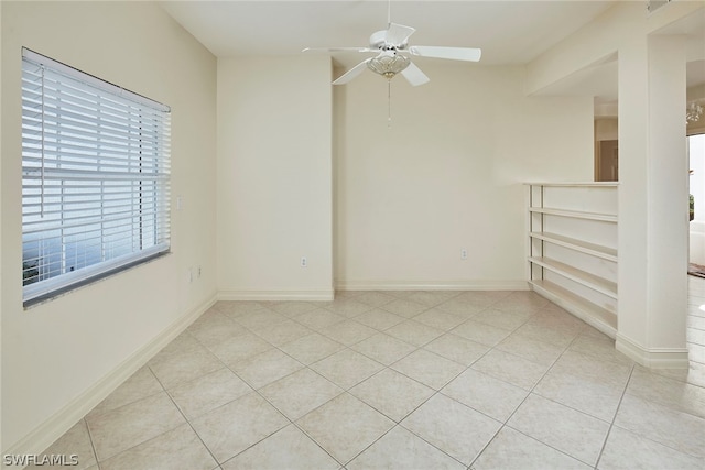 tiled empty room featuring ceiling fan