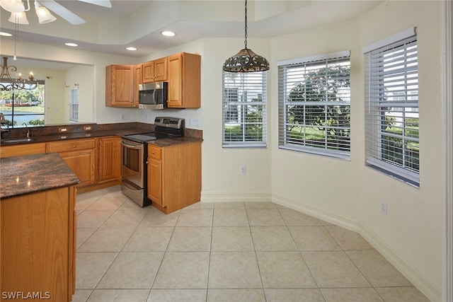 kitchen featuring pendant lighting, sink, a healthy amount of sunlight, appliances with stainless steel finishes, and ceiling fan with notable chandelier