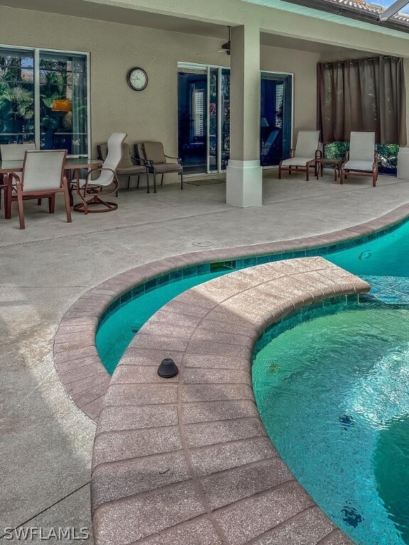 view of pool with a patio area and ceiling fan