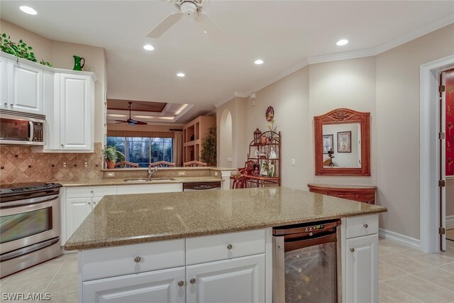 kitchen featuring wine cooler, sink, white cabinetry, and stainless steel appliances