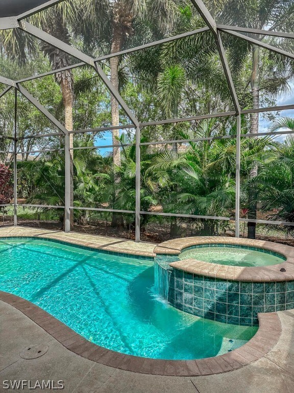 view of pool featuring an in ground hot tub and a lanai