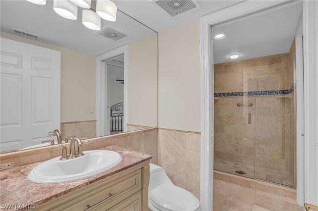 bathroom with toilet, large vanity, tile walls, tile flooring, and an enclosed shower