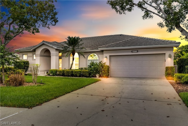 view of front of home with a garage and a yard