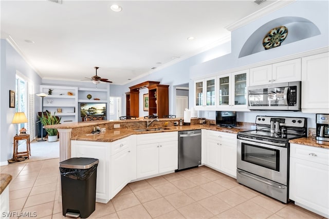 kitchen with light tile floors, kitchen peninsula, ceiling fan, and stainless steel appliances