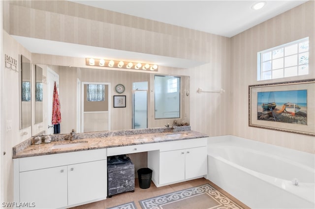 bathroom featuring a bathing tub, tile floors, and dual bowl vanity