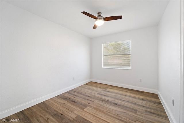 spare room with dark hardwood / wood-style floors and ceiling fan