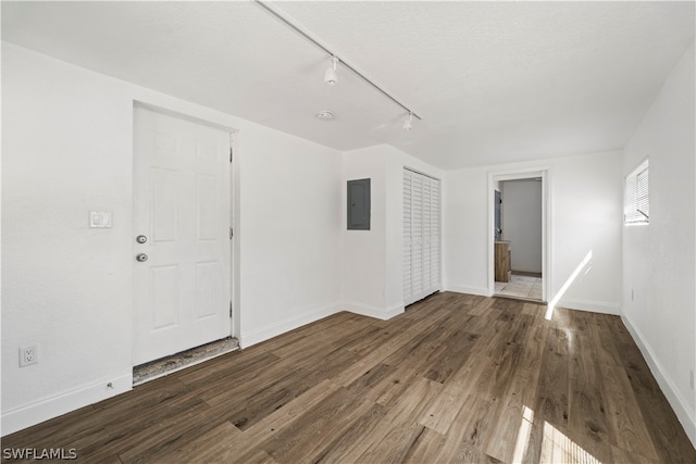 empty room featuring rail lighting and dark hardwood / wood-style floors