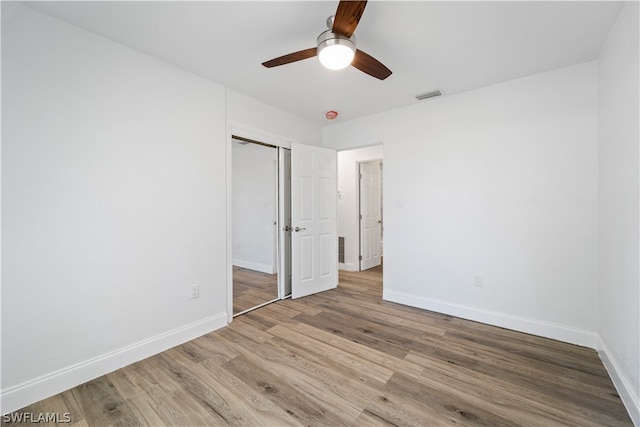 unfurnished bedroom featuring a closet, ceiling fan, and light wood-type flooring