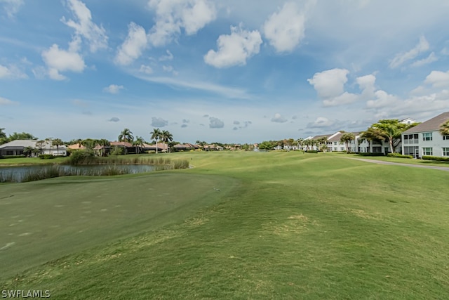 view of home's community with a lawn and a water view