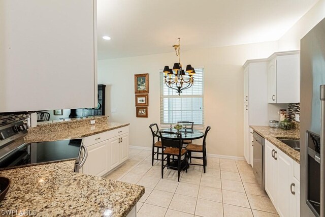 kitchen featuring light tile patterned flooring, a chandelier, hanging light fixtures, appliances with stainless steel finishes, and white cabinets