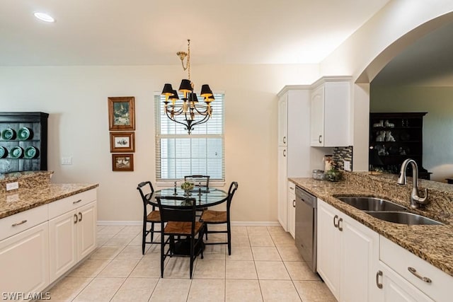 kitchen with stone countertops, dishwasher, sink, and white cabinets