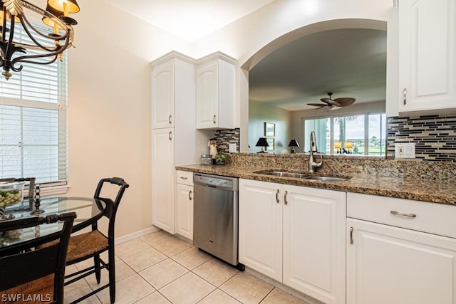 kitchen featuring sink, dark stone countertops, stainless steel dishwasher, ceiling fan with notable chandelier, and white cabinets