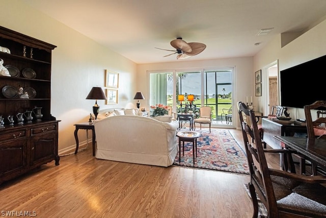 living room with ceiling fan and light hardwood / wood-style flooring