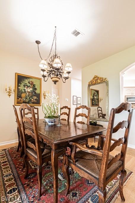 dining space featuring a notable chandelier and light hardwood / wood-style flooring