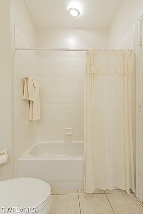 bathroom featuring toilet, tile patterned flooring, and shower / bath combo with shower curtain