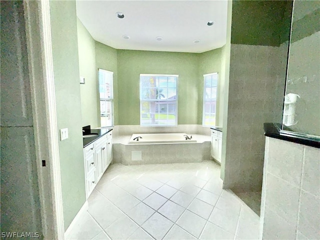 bathroom featuring tile patterned flooring, walk in shower, a bath, and vanity