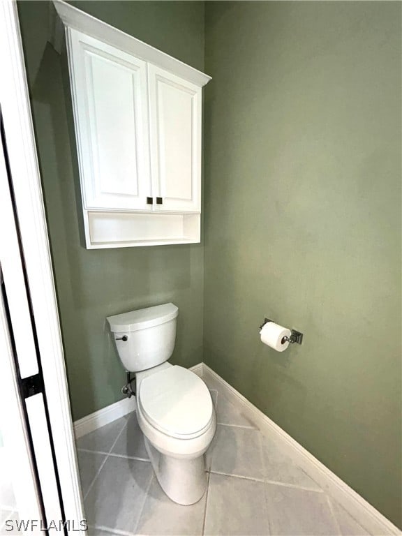 bathroom with toilet and tile patterned flooring