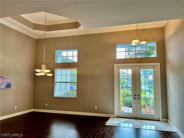 foyer entrance featuring french doors, crown molding, a chandelier, and hardwood / wood-style floors