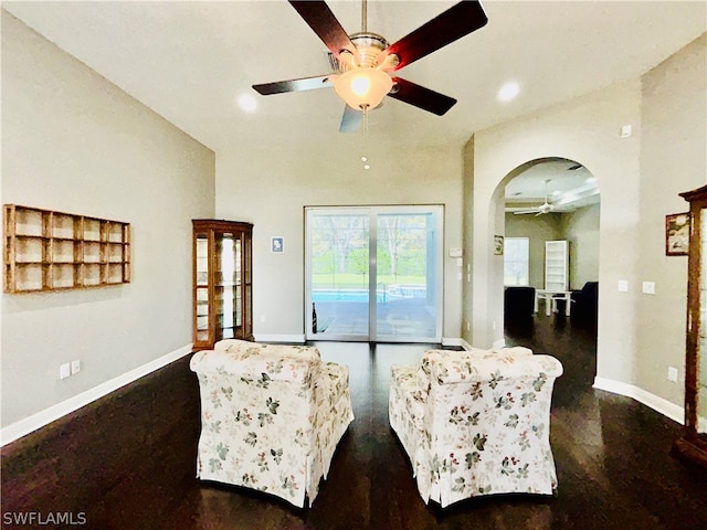 living room with ceiling fan and dark hardwood / wood-style floors