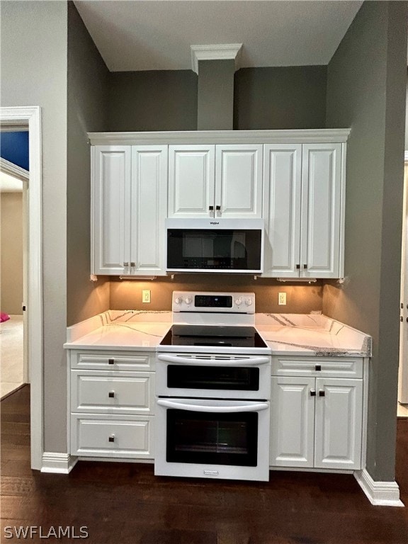 kitchen with light stone counters, dark wood-type flooring, range with two ovens, and white cabinets