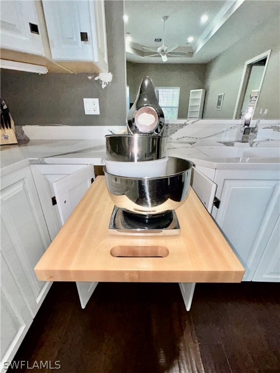 room details with ceiling fan, sink, white cabinetry, and wooden counters