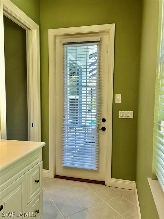 doorway to outside with light tile patterned floors