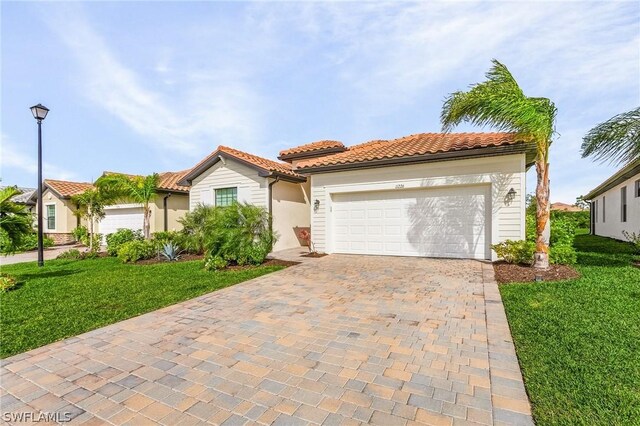 mediterranean / spanish home featuring a front lawn and a garage