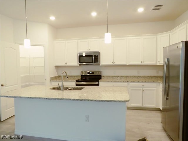 kitchen with decorative light fixtures, an island with sink, sink, and stainless steel appliances