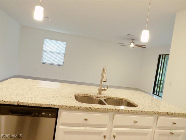 kitchen featuring pendant lighting, white cabinetry, sink, light stone counters, and stainless steel dishwasher