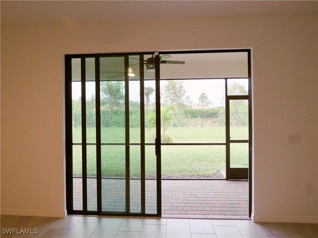 doorway to outside with ceiling fan, light tile patterned floors, and a healthy amount of sunlight