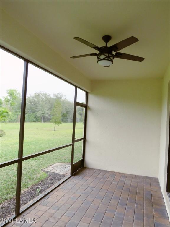 unfurnished sunroom featuring ceiling fan