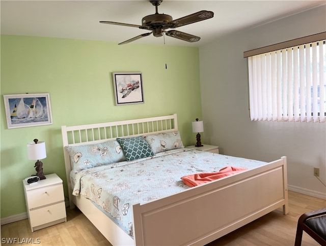 bedroom with multiple windows, ceiling fan, and light wood-type flooring