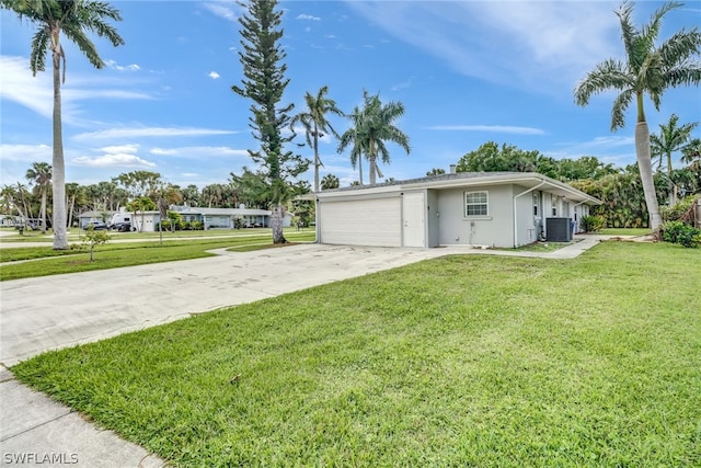 view of front of house featuring an attached garage, central AC unit, concrete driveway, and a front yard