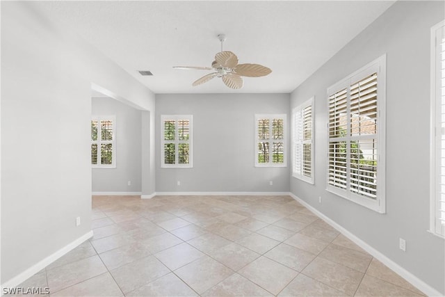 empty room with ceiling fan and light tile patterned floors