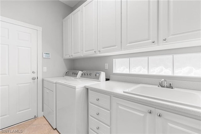 laundry room featuring washer and clothes dryer, light tile patterned flooring, cabinets, and sink