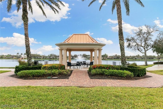 view of property's community with a lawn and a water view