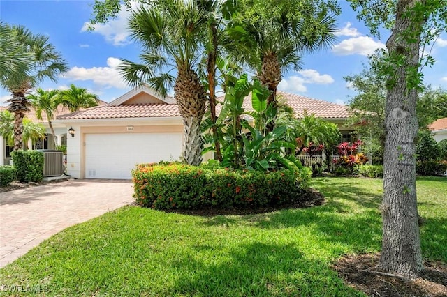 mediterranean / spanish-style house with cooling unit, a front lawn, and a garage