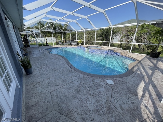 view of swimming pool featuring an in ground hot tub, a patio, and a lanai