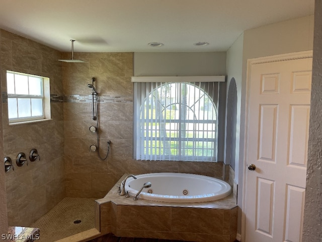 bathroom with independent shower and bath and a healthy amount of sunlight