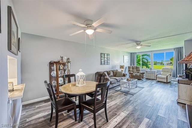 dining space featuring ceiling fan and dark wood-type flooring