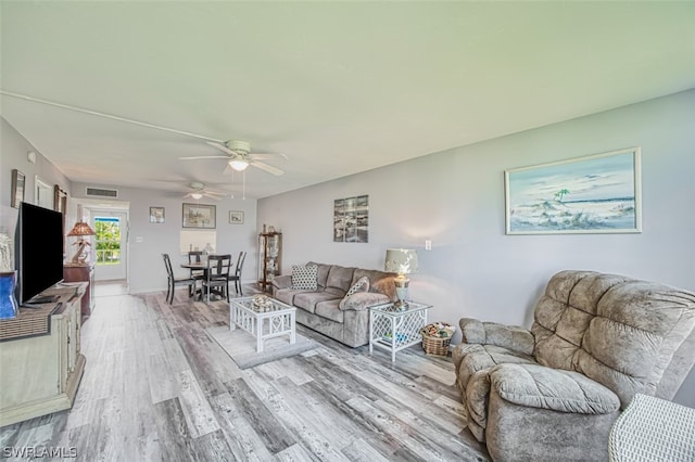 living room featuring ceiling fan and hardwood / wood-style flooring