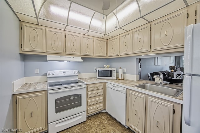 kitchen featuring cream cabinets, sink, a drop ceiling, and white appliances