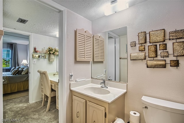 bathroom with vanity, a textured ceiling, and toilet